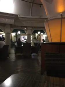 چند نفر نشسته پشت میزهای رستورانیی در مرکز خرید مدرن الهیه