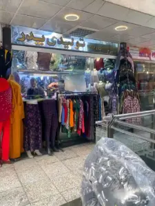 تصویر مغازه فروش پوشاک و فروشنده آن در بازار بزرگ بهارستان