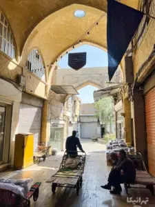 چند نفر نشسته دبازار دروازه‌نو و پشت دروازه محمدیه بازار بر روی چرخ باربری و یک نفر در حال تردد داخل این بازار