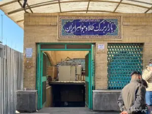 چند مرد ایستاده در گوشه تصویر کنار ورودی بازار طلا و جواهر ایران