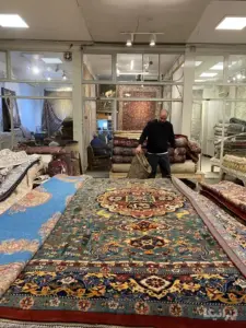 مردی در حال تردد در بازار فرش ایران