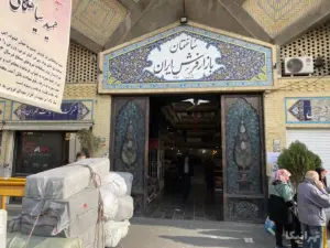 مردم در حال تردد در بازار فرش ایران و مقابل آن در خیابان خیام
