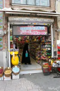 زنی در فروشگاه قهوه و شکلاتی در بازار کوچه مروی درحال خرید