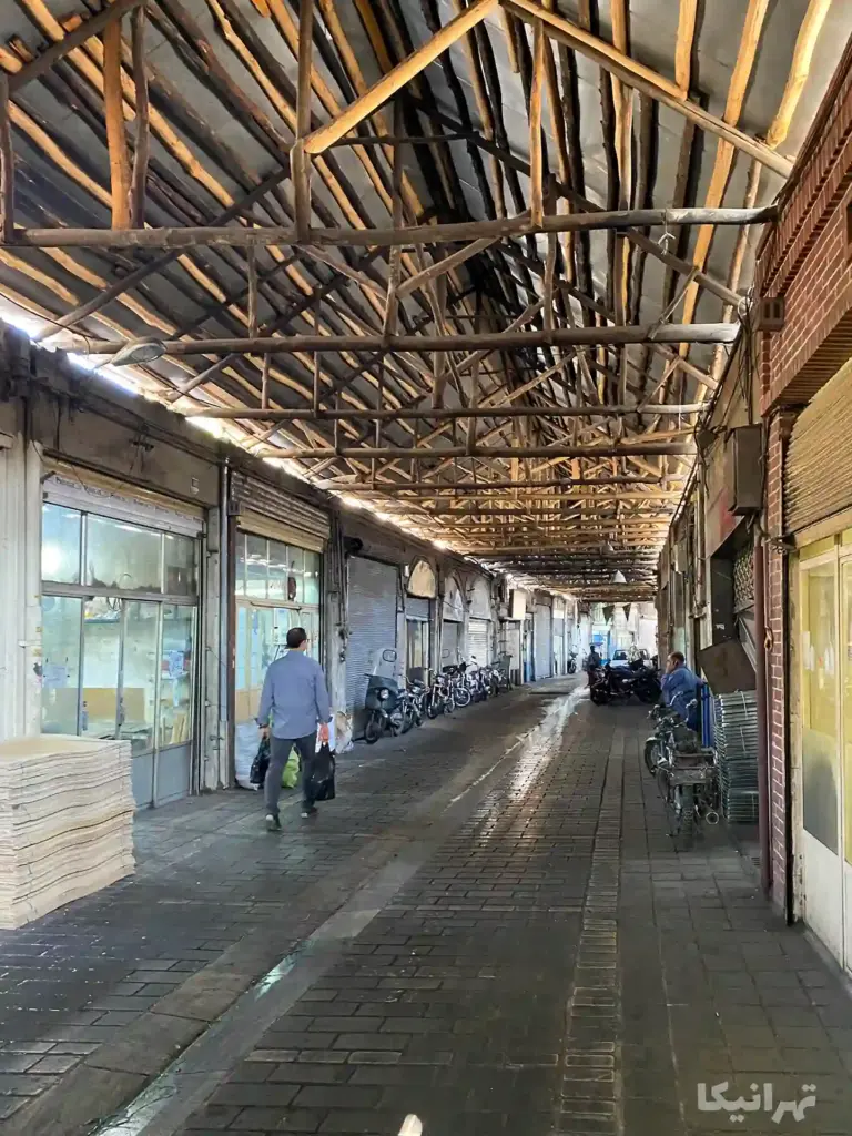 مردی وسایل در دست در حال عبور از بازارچه مسقف نایبالسلطنه