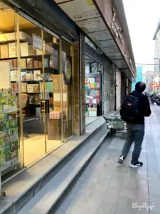 مردی در جلوی کتاب‌فروشی‌های کوچه حاج‌نایب ناصرخسرو ایستاده