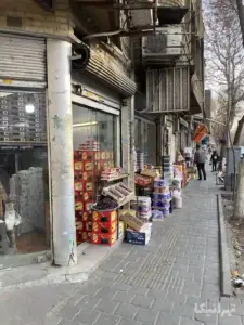 مردی ایستاده در جلوی مغازه خرمافروشی خیابان تختی