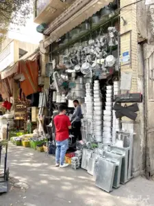 چند نفر در حال خرید از مغازه ظروف و منقل فروشی در خیابان سیروس
