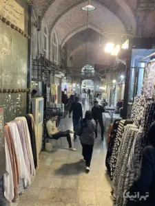 زنی در حال راه رفتن از میان دو مرد در دالان دوم ملک بازار