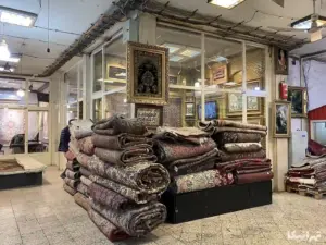 فرش‌های چیده‌شده در جلوی یک مغازه فرش دستباف‌فروشی در سرای فاطمیه بازار