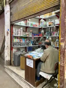 مردی نشسته در مغازه خود در سرای مستوفی بازار