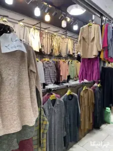 لباس‌های زنانه چیده شده رو رگال در یک مغازه سرای ملی