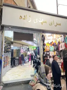 مردم در حال تردد در کوچه حمام‌چال بازار از مقابل سرای مهدی‌زاده بازار