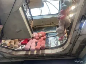 عروسک‌های آویزان شده از نرده‌های طبقه دوم سرای پایدار بازار