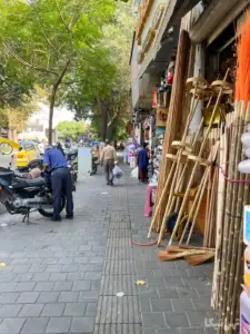 مردی ایستاده کنار موتورسیکلت در پیاده‌روی خیابان صاحب‌جمع