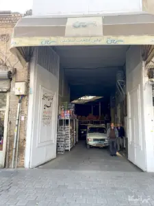 دو نفر از یک گاراژ مواد غذایی در میدان محمدیه خارج می‌شوند