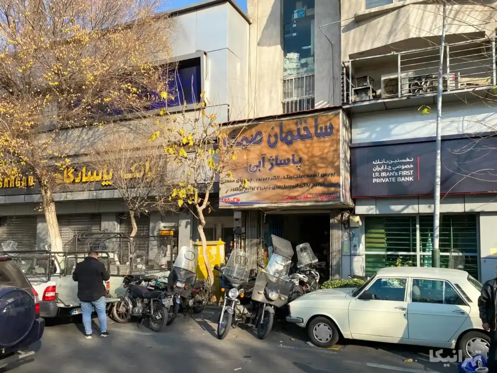 مردی در جلوی پاساژ آبی چراغ برق ایستاده است