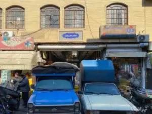 دو نفر جلوی پاساژ ایران بازار ایستاده‌اند