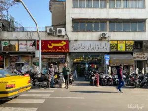 چند نفر در مقابل پاساژ ایران خیابان ملت ایستاده‌اند