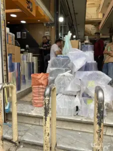 چند نفر در حال خرید از مغازه‌ای در پاساژ بوذرجمهری بازار