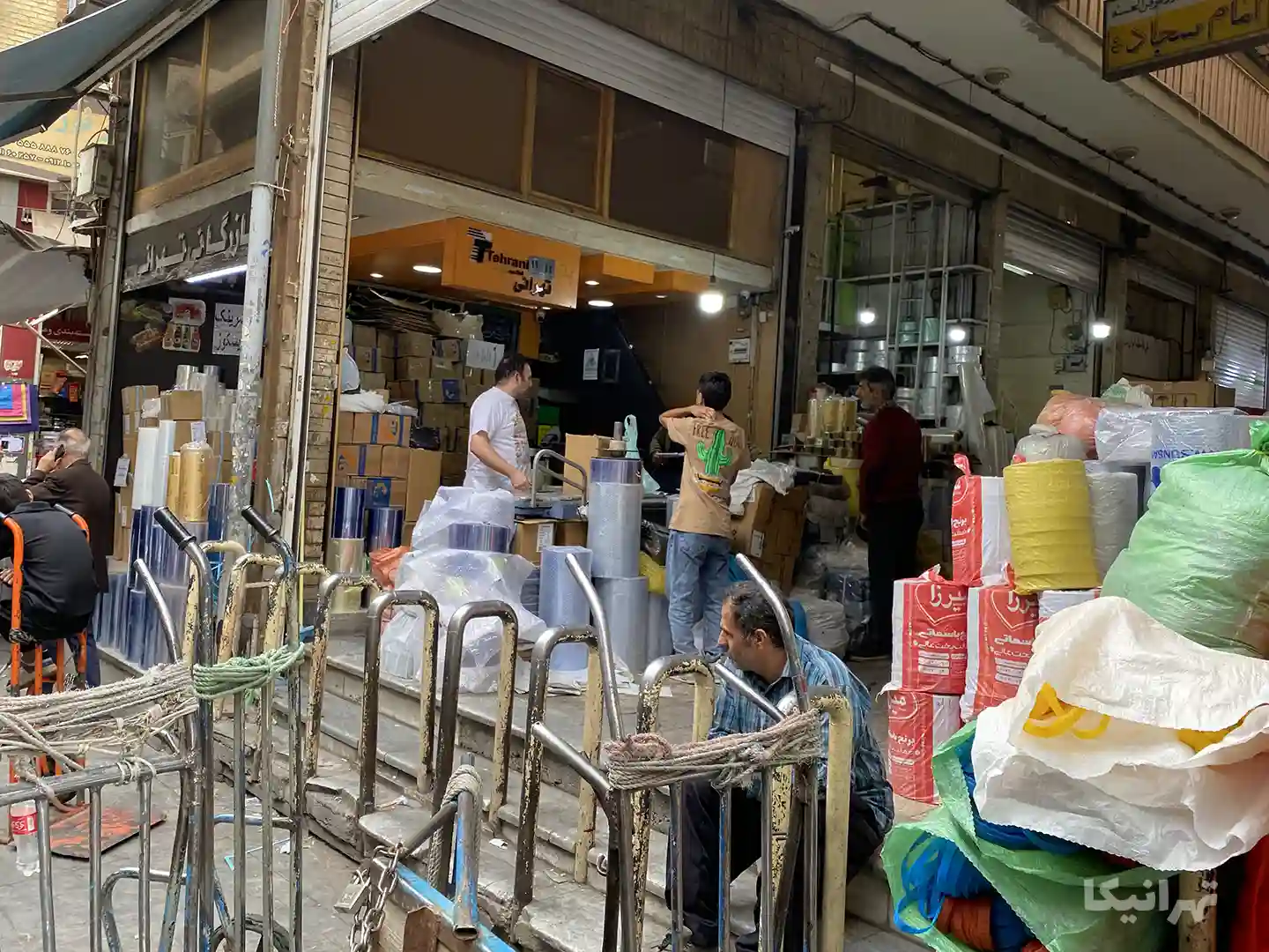 چند نفر در حال خرید از مغازه‌ای در پاساژ بوذرجمهری بازار