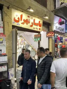 مردم در حال عبور از مقابل ورودی پاساژ تهران در بازار بزازها