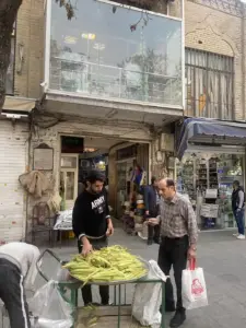 مردی در حال خرید از دستفروش در جلوی پاساژ جعفری بازار