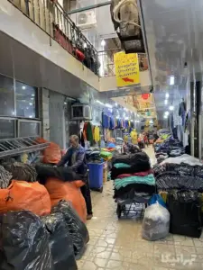 مردی در حال بسته‌بندی کردن پوشاک در پاساژ جلالی نوی بازار