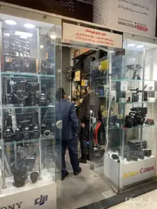 دو مرد داخل مغازه لوازم عکاسی در حال خرید داخل پاساژ جوانمرد