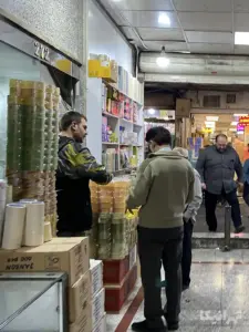 مردی در حال خرید چسب از مغازه‌داری در پاساژ زردوز بازار