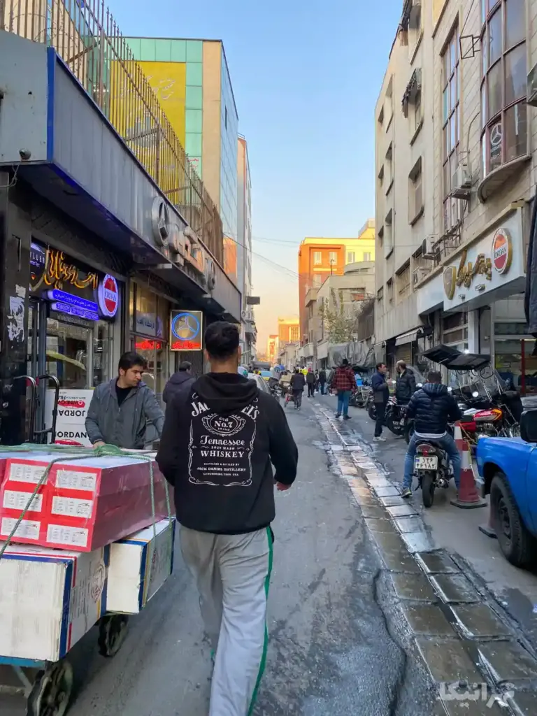 مردم در حال تردد از مقابل پاساژ سراج‌الملک چراغ برق