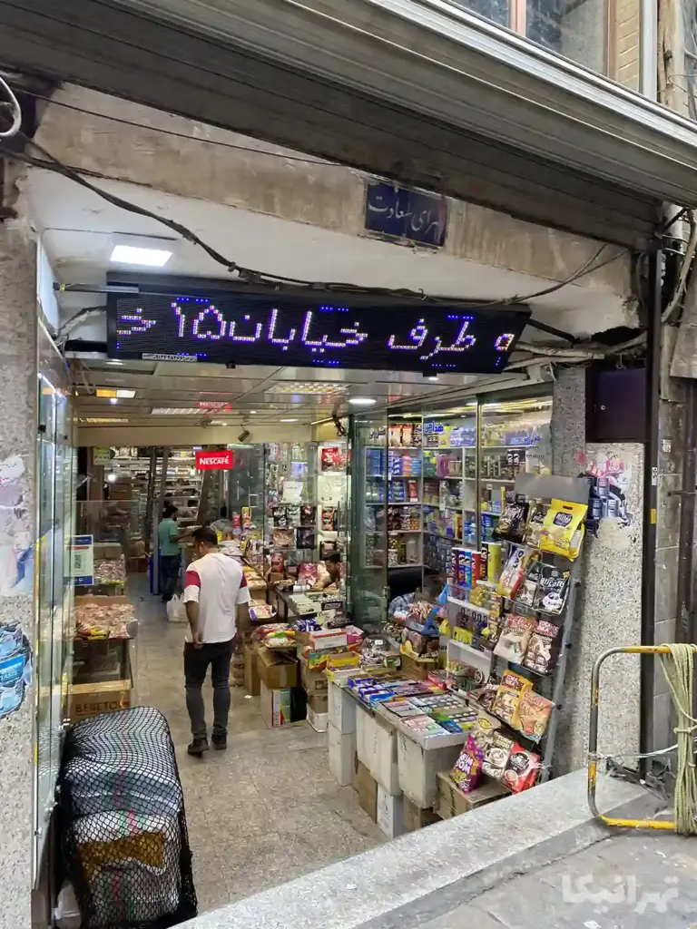 چند نفر در حال نگاه کردن به ویترین مغازه‌های مواد غذایی
