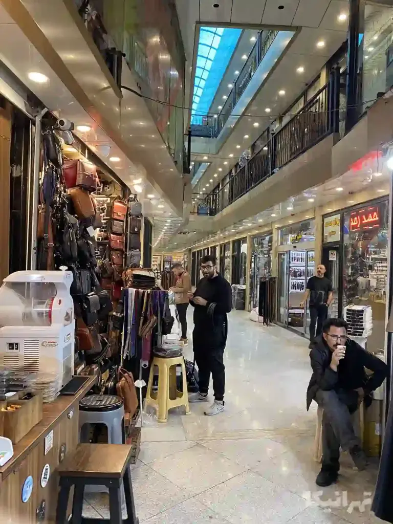 چند مرد داخل پاساژ صفای بازار آهنگران ایستاده‌اند