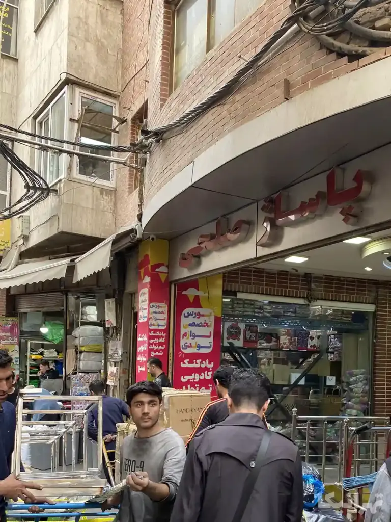 مردم در حال تردد از جلوی پاساژ صلحی در کوچه معظم‌الدوله
