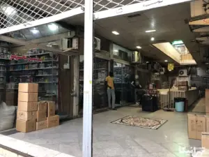 مردی در پاساژ طالب بازار مشغول بسته‌بندی است
