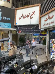 چند نفر مقابل پاساژ طبس فردوسی ایستاده‌اند