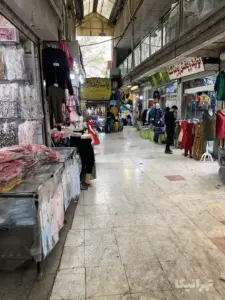 مردی جلوی مغازه‌ای در بازار مسگرها ایستاده است
