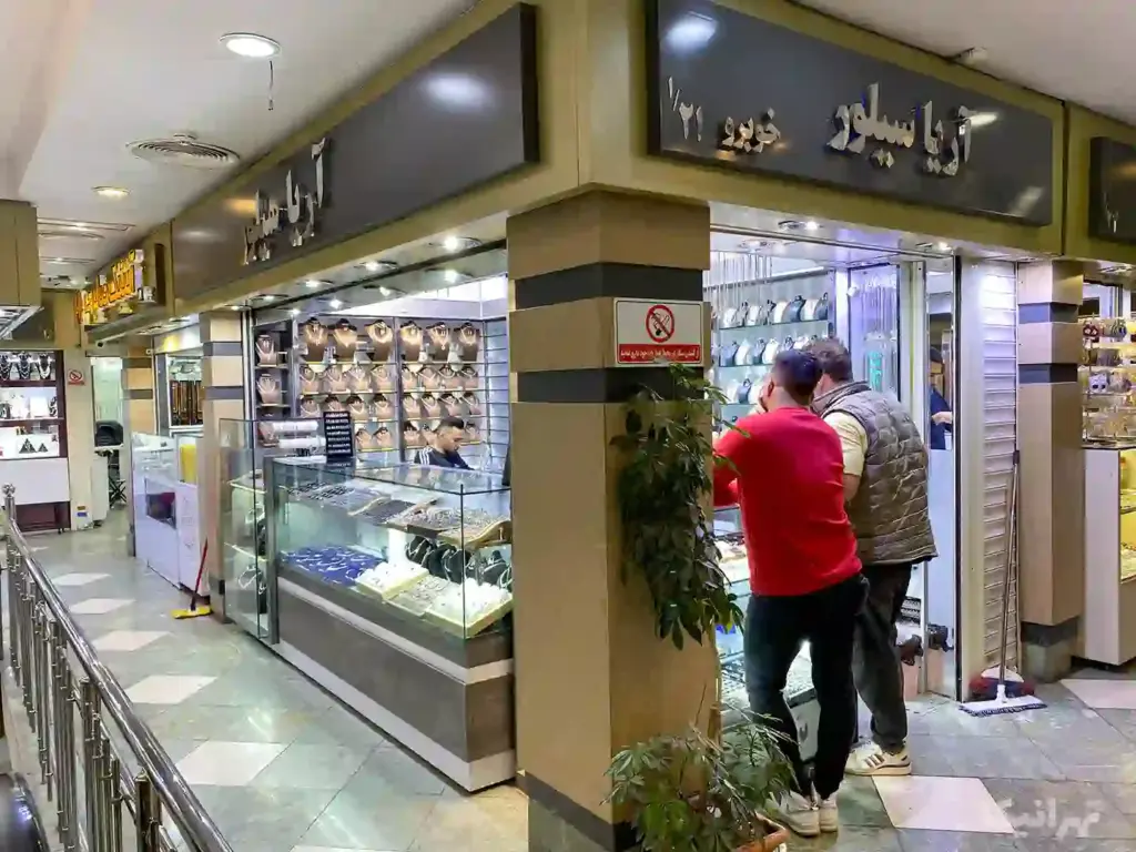 دو مرد جلوی ویترین مغازه‌ای در پاساژ غدیر بازار