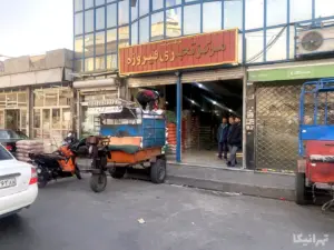 چند مرد جلوی پاساژ فیروزه محمدیه ایستاده به مردی در حال جابه‌جایی بار است نگاه می‌کنند