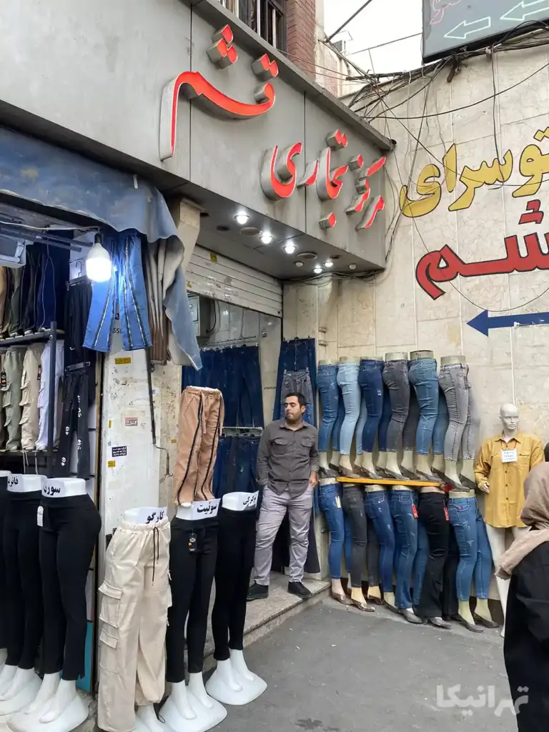 مردی جلوی ورودی پاساژ قشم بازار مسگرها ایستاده