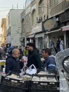 مردم در جلوی پاساژ مروارید در کوچه احمدی بازار ایستاده‌اند