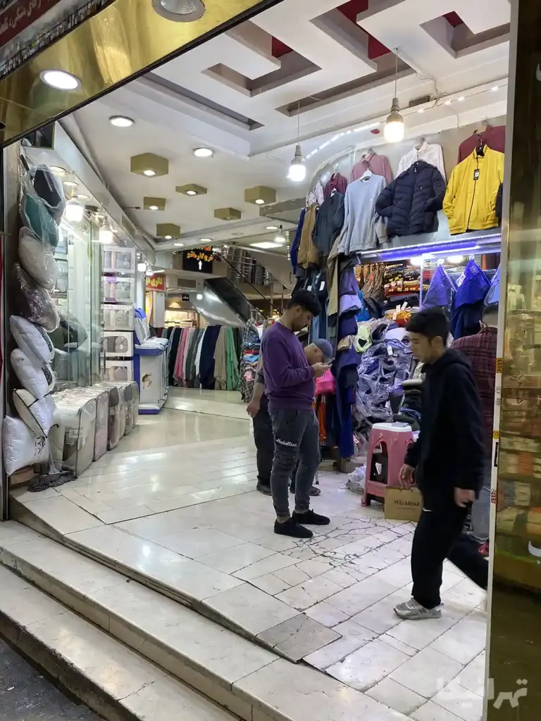 چند نفر در ورودی پاساژ مریم بازار ایستادهاند