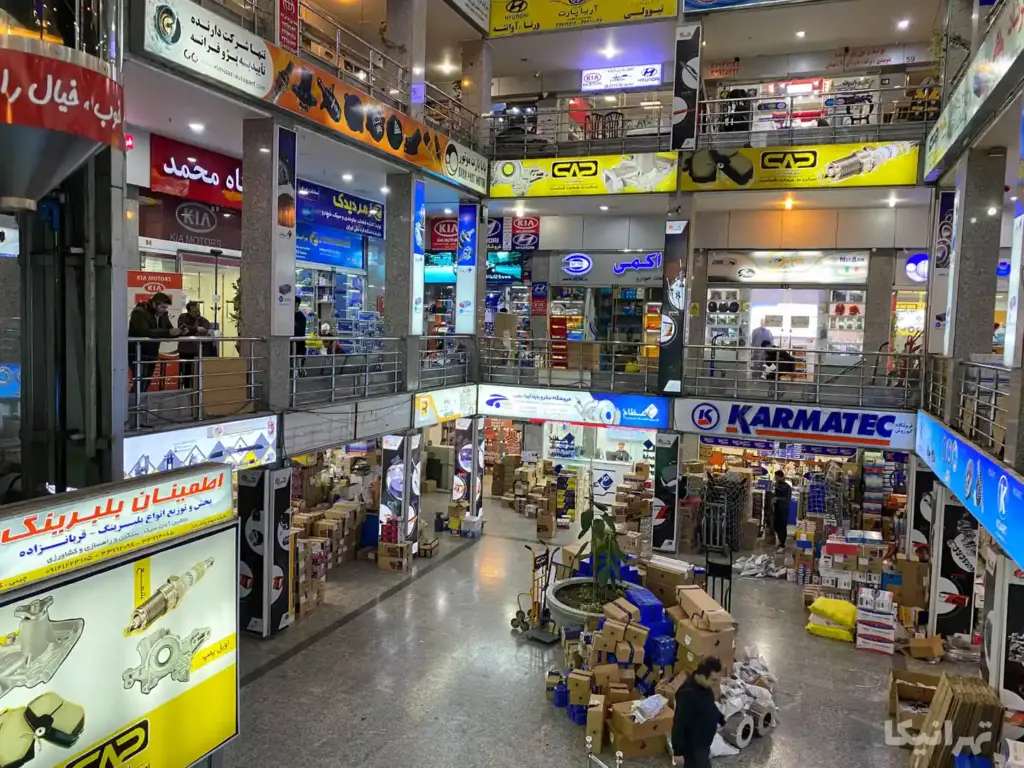 چند نفر در طبقات مختلف پاساژ معصومی چراغ برق ایستاده‌اند