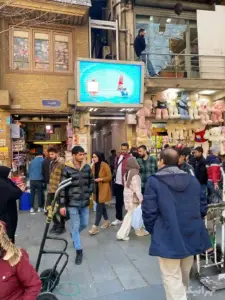 مردم در حال عبور از جلوی ورودی پاساژ موثقی در خیابان ۱۵ خرداد