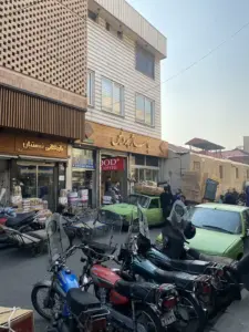 چند نفر در حال حمل مواد غذایی در جلوی پاساژ پردیس مولوی در کوچه احمدی
