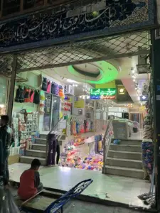 دو نفر در جلوی ورودی پاساژ کویتی‌های عباس‌آباد بازار ایستاده‌اند