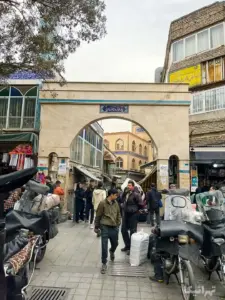 مردم درحال عبور و مرور از زیر سردر پله نوروزخان بازار