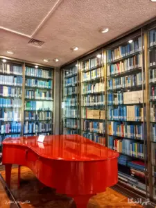 پیانوی جلوی قفسه کتاب‌های کتابخانه اختصاصی کاخ نیاوران