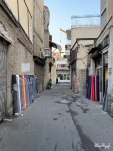 چرم‌های چیده‌شده در کنار دیوار کوچه بهبهانی در مقابل یک مغازه