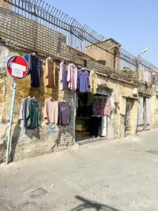 لباس‌های چیده‌شده جلوی ورودی یک تولیدی پوشاک در بازار
