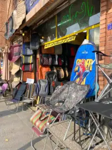 روکش‌‌ صندلی‌های چیده شده از مقابل و درون یک مغازه در کوچه کوکب چراغ برق